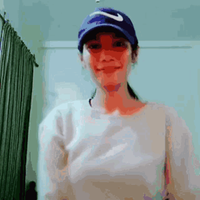 a woman wearing a nike hat is smiling