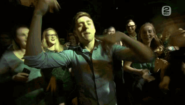 a man dancing in front of a crowd with the number 2 on the bottom