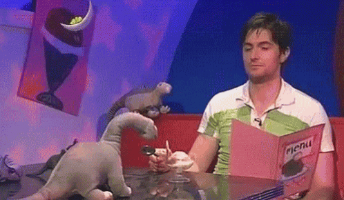 a man is sitting at a table holding a menu