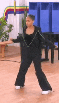 a girl in a black outfit is dancing in a room with blue lockers