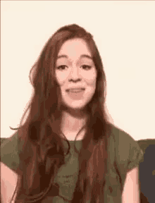 a woman with long red hair is making a funny face .