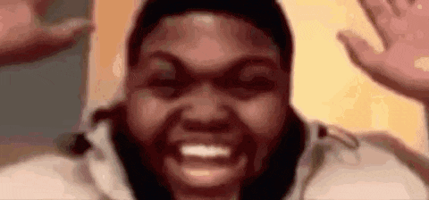 a close up of a person 's face with a beard and a smile .