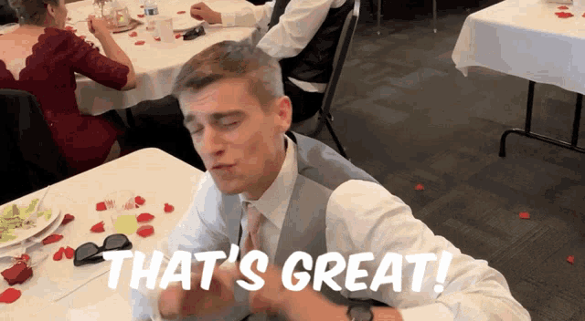 a man sitting at a table with the words that 's great