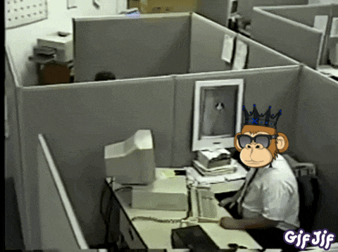 a monkey wearing sunglasses and a crown sits at a desk in an office cubicle