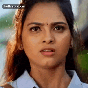 a close up of a woman 's face with a serious expression .