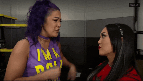 a woman with purple hair is wearing a purple shirt that says i 'm a doll