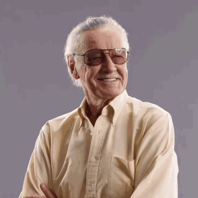 an older man wearing glasses and a yellow shirt is smiling