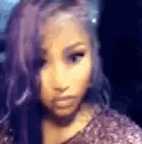 a woman with purple hair is taking a selfie with her phone .