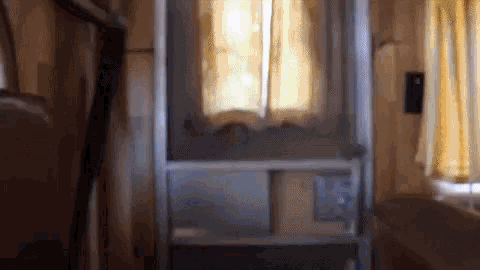 a blurry picture of a room with a window and a ladder