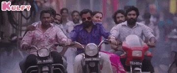 a group of people riding motorcycles down a street .