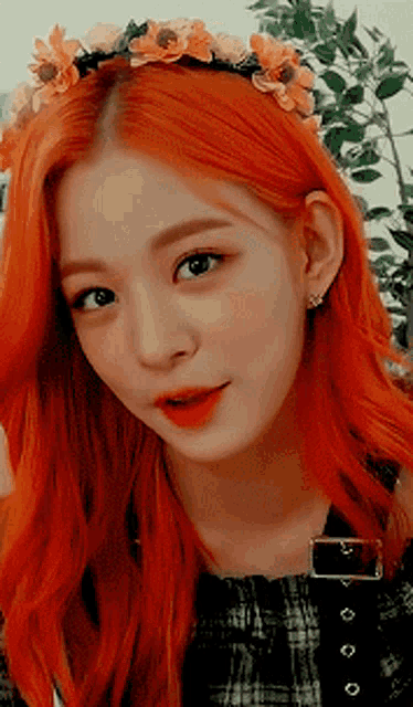 a woman with red hair is wearing a flower crown
