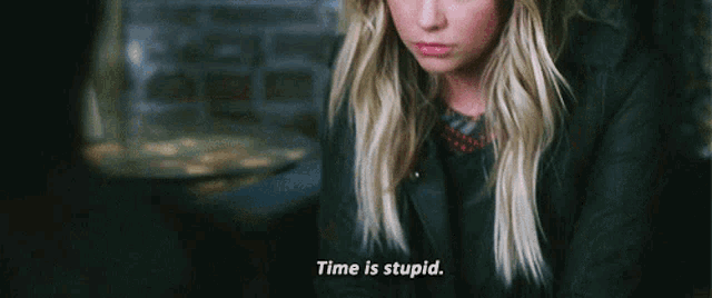 a woman in a black jacket is saying time is stupid .