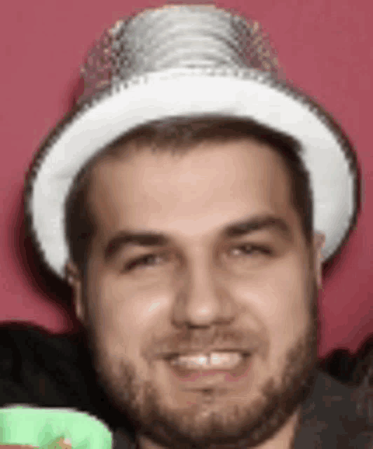 a man with a beard wearing a white hat and smiling