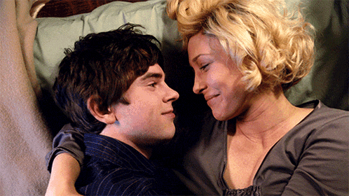 a man and a woman are looking at each other in bed