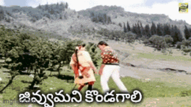 a man and a woman are dancing in a field with mountains in the background and the words in telugu