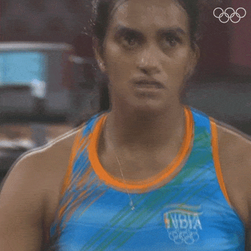 a close up of a woman wearing a blue and orange tank top with the word india on it
