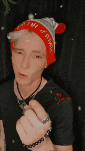 a man wearing a red hat that says " christmas " on it