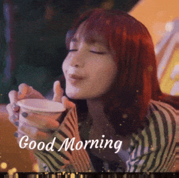 a woman with red hair is drinking from a cup with the words good morning written on it