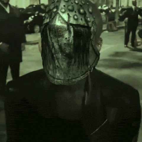 a man with a helmet on his head stands in a parking lot
