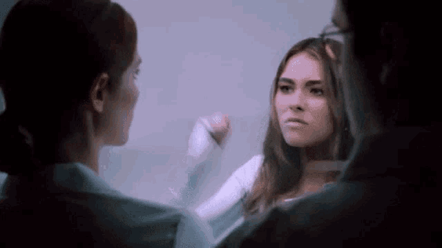 a woman with a cast on her arm is talking to a man and a woman .