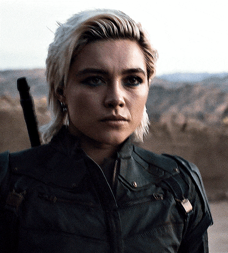 a close up of a woman 's face with a sword in her hand
