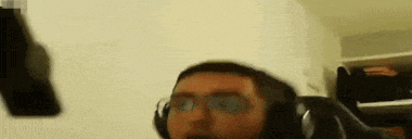 a man wearing headphones is sitting in a chair and holding a cell phone in his hand .
