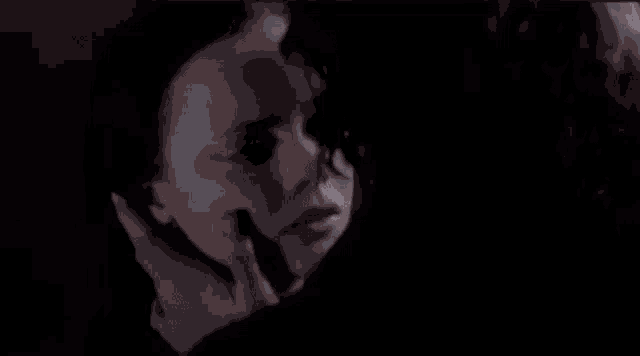 a man and a woman are kissing in the dark in a dark room .