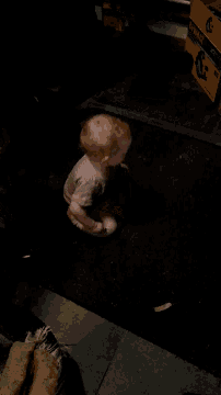 a baby is laying on a black carpet in front of a yellow box that says ' sd ' on it