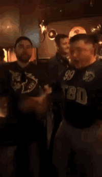 a man wearing a shirt that says tbd is dancing with another man