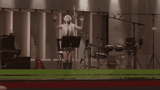 a woman singing into a microphone in front of a roland keyboard