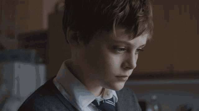 a close up of a boy 's face with a tear coming out of his eye