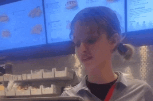 a woman is standing in front of a menu in a restaurant .