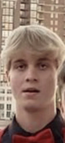 a close up of a young man 's face with a bow tie .