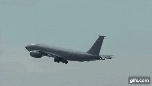 a large military jet is flying in the sky .
