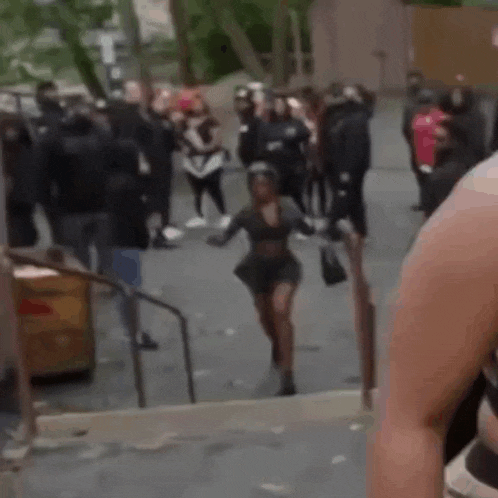 a group of people are walking down stairs and a woman is running down them .