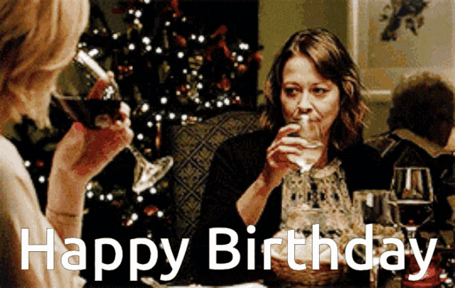 two women sitting at a table drinking wine with the words happy birthday written above them