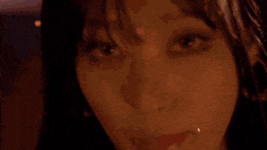 a close up of a woman 's face wearing earrings and a scarf .