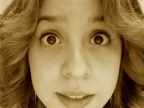 a close up of a woman 's face with her eyes wide open