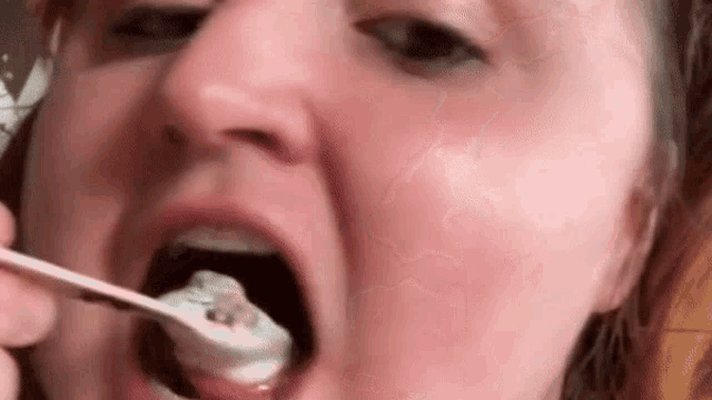 a woman is eating ice cream with a spoon .