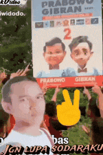 a man is holding up a sign that says prabowo gibran 2