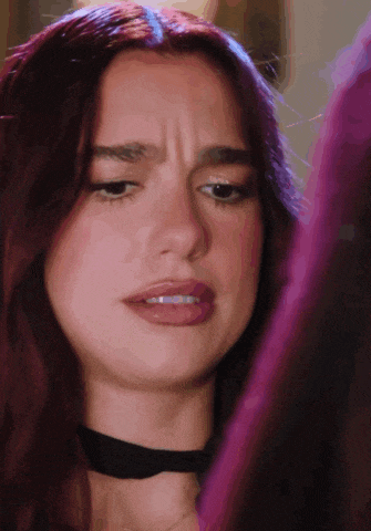 a close up of a woman 's face with red hair and a black choker