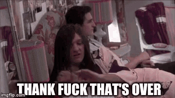 a woman is laying on a man 's lap with the words thank fuck that 's over written below her