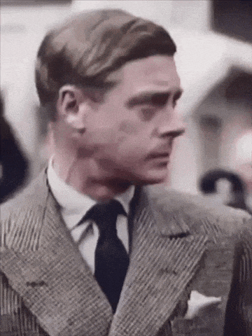 a man in a suit and tie is looking to his left