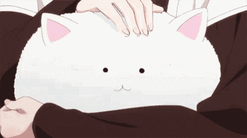 a person is petting a stuffed animal that looks like a cat .