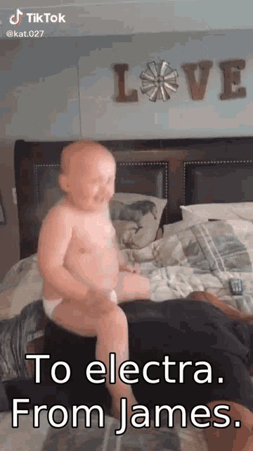 a baby in a diaper sitting on a bed with the words to electra from james