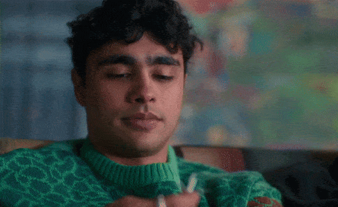 a man wearing a green and red sweater looks to his left