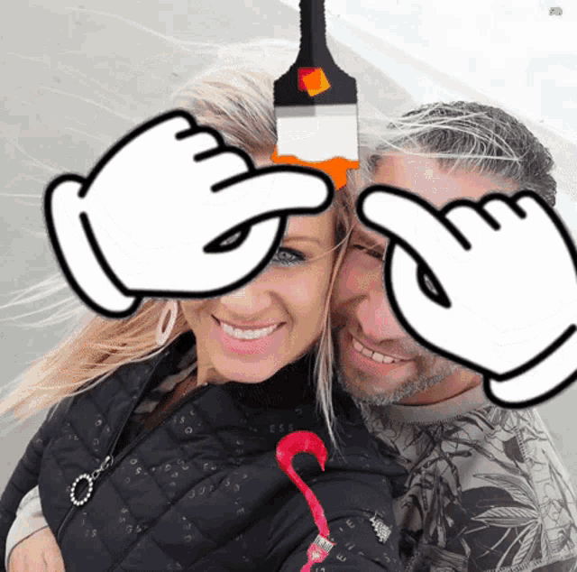 a man and a woman are posing for a picture with their hands covering their eyes