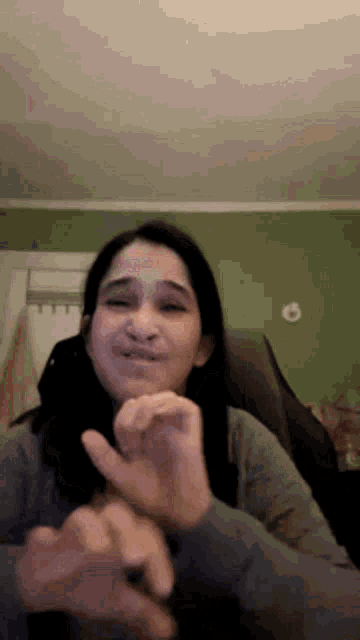 a woman is making a funny face with her fingers