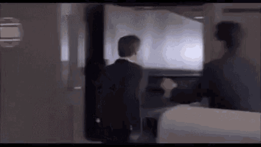 a man in a suit is standing next to another man in a suit in a room .