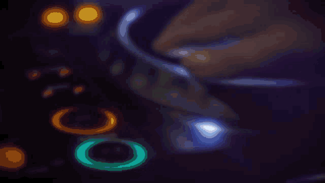 a blurred image of a dj 's controller with glowing circles in the middle